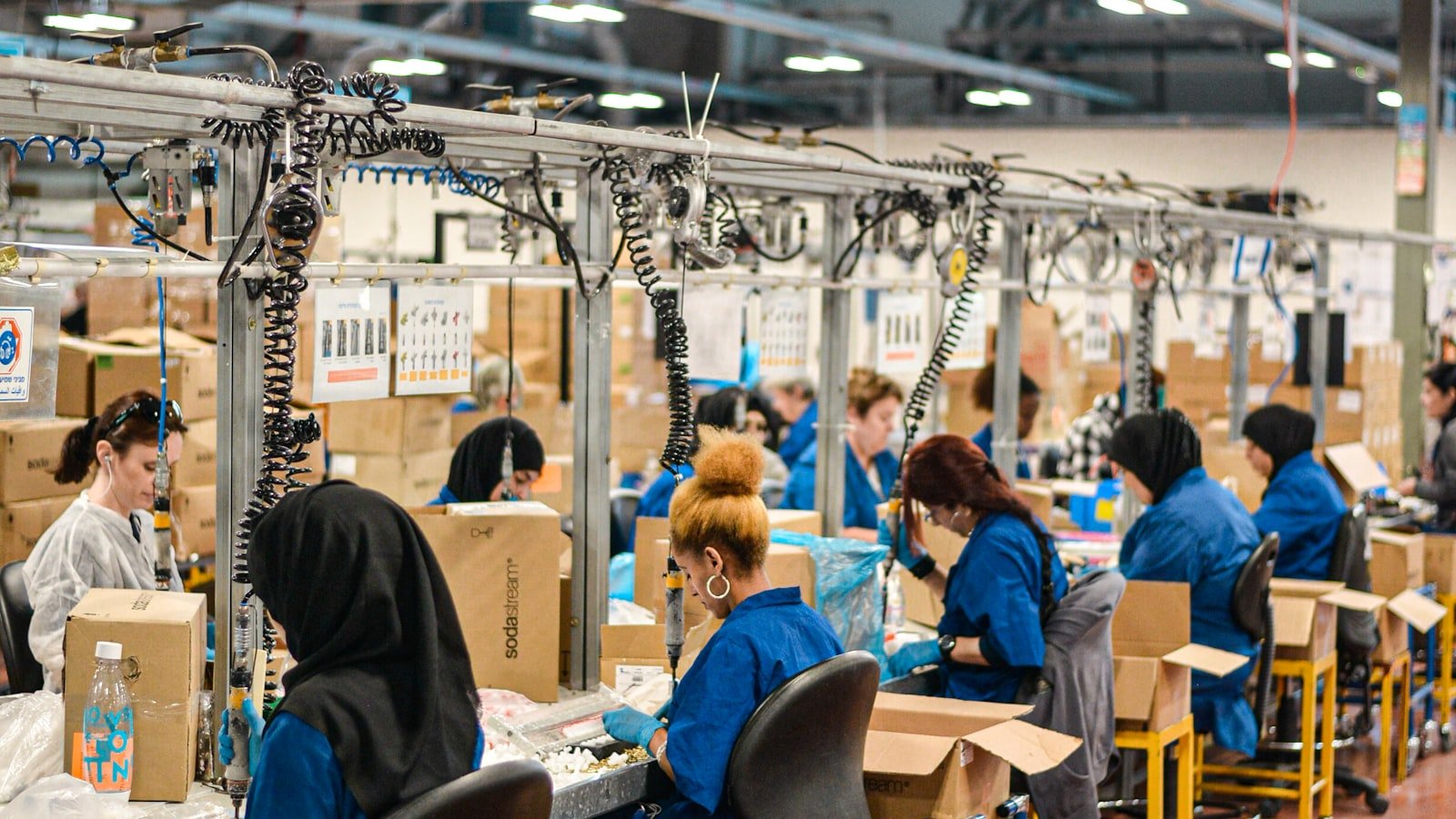 White thobe fabric moving along a factory assembly line, representing the bulk production capacity behind an approved sample order